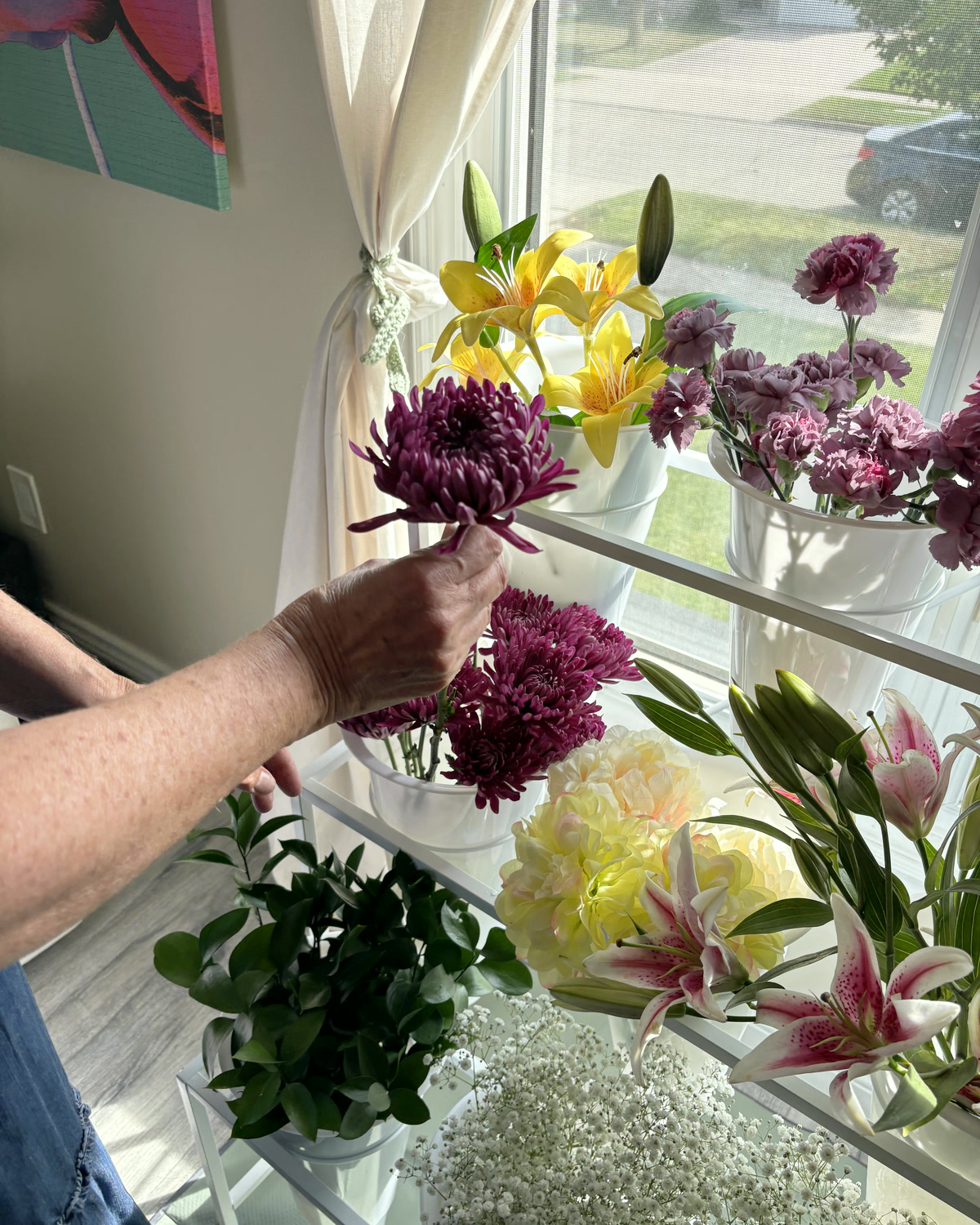 A guest lifting a purple chrysanthemum from the bar in afternoon light