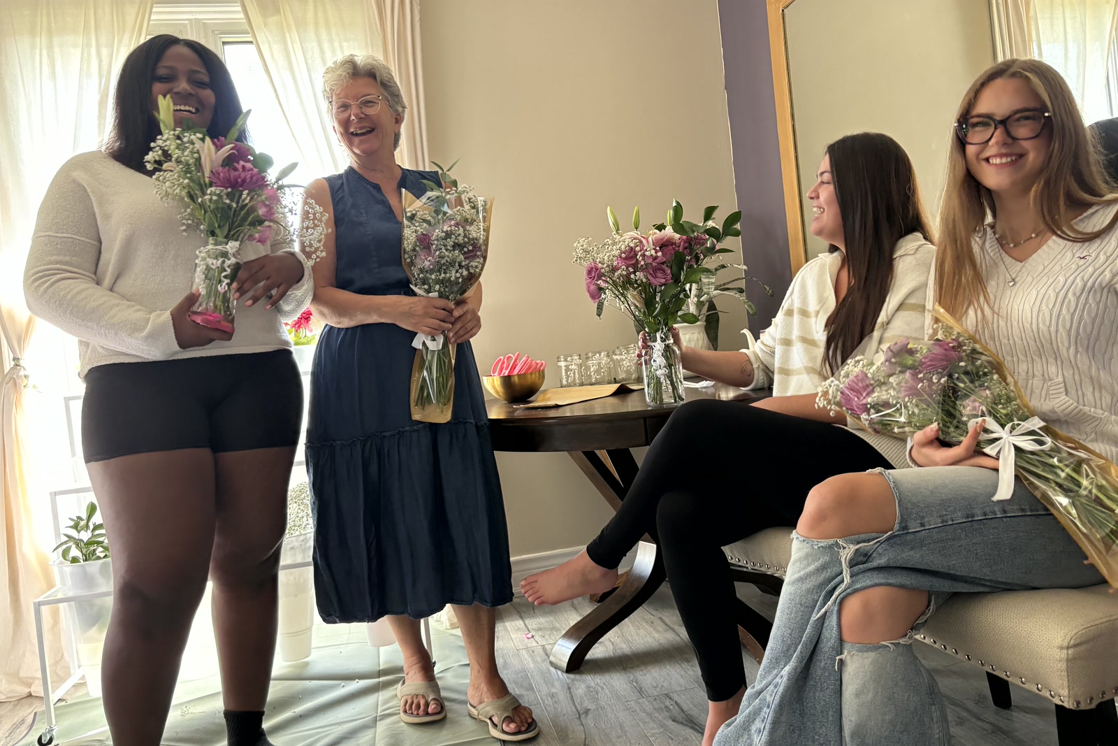 Four guests laughing with their finished bouquets